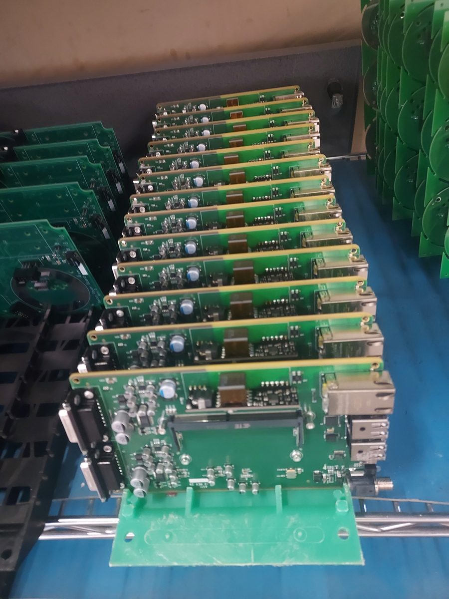 Completed circuit board assemblies racked in ESD-safe carriers, ready for inspection and test.