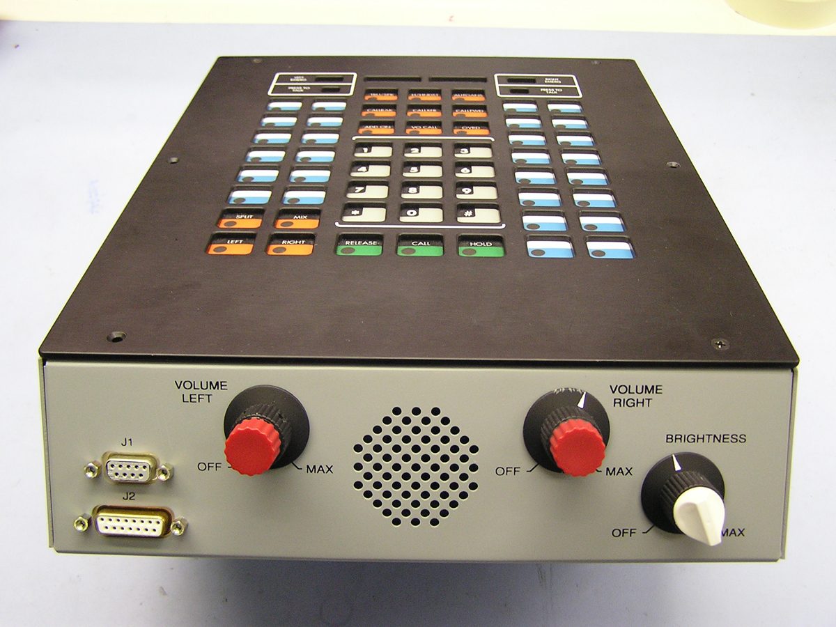 A completed communications console built by Kerrydale Technologies, with backlit selector keys, a numeric keypad, dual volume controls and a front-panel speaker.